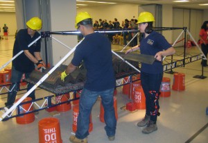 Standing the Strain: Max Schisler, Aaron Chan and Stephanie Rindosh test their bridge by loading it with 96 25-pound plates. 