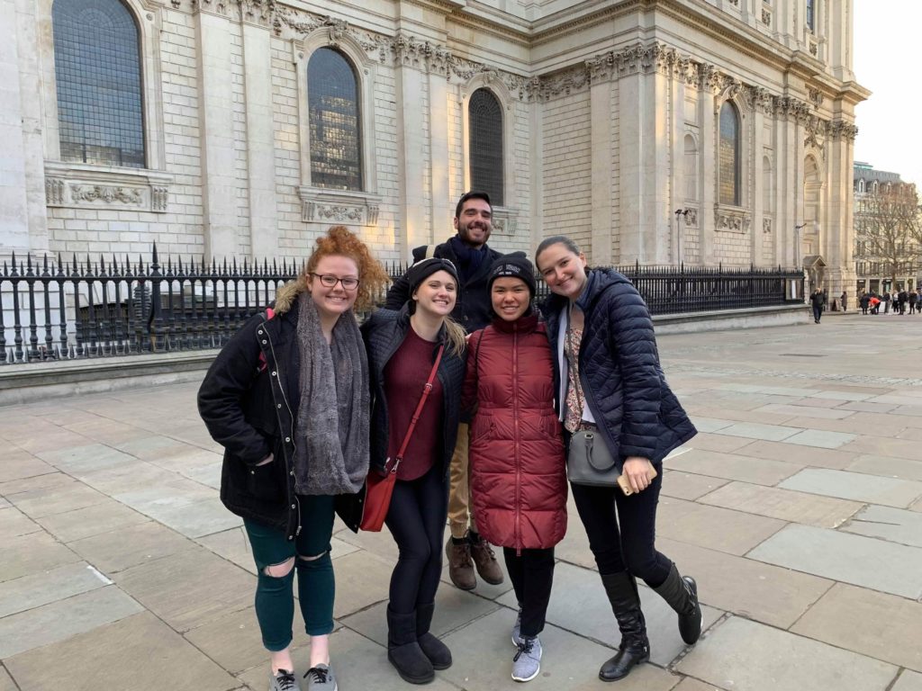 group posing in front of large cathedral