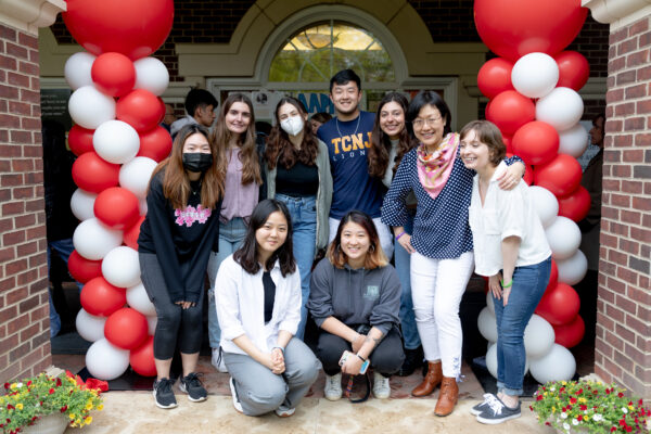 group of students flanked by red and white balloon columns