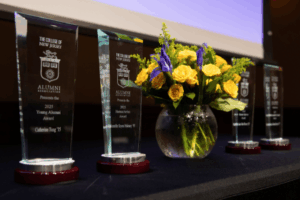 awards from 2025 leadership award ceremony lined up on a table with blue and yellow flower arrangement in the enter